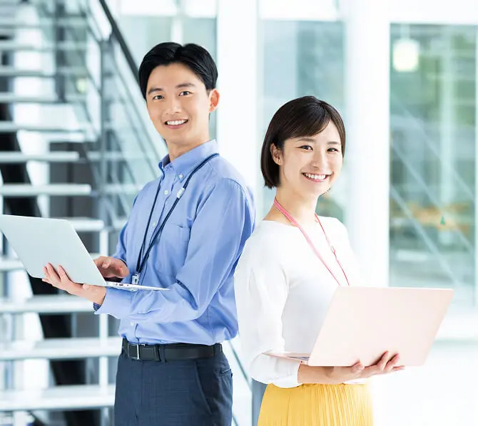 ノートパソコンを持っている男女の会社員