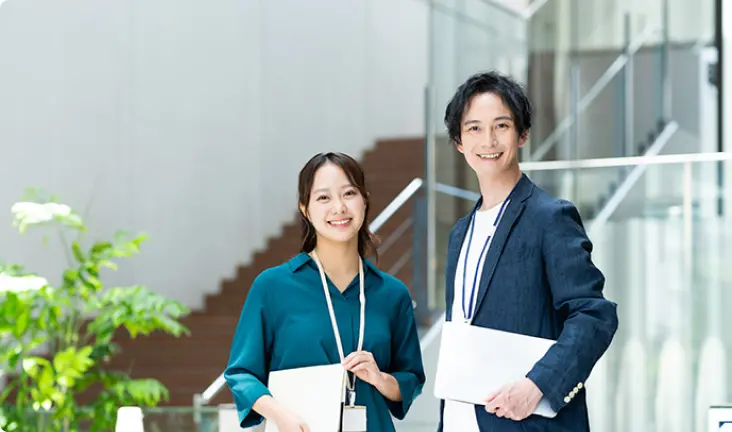 笑顔でただずむ男女の画像