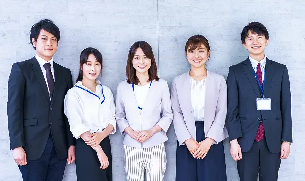 スーツを着て笑顔で並ぶ5人のビジネスパーソン