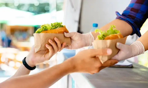 屋外イベントでのフード提供と受け渡しのシーン